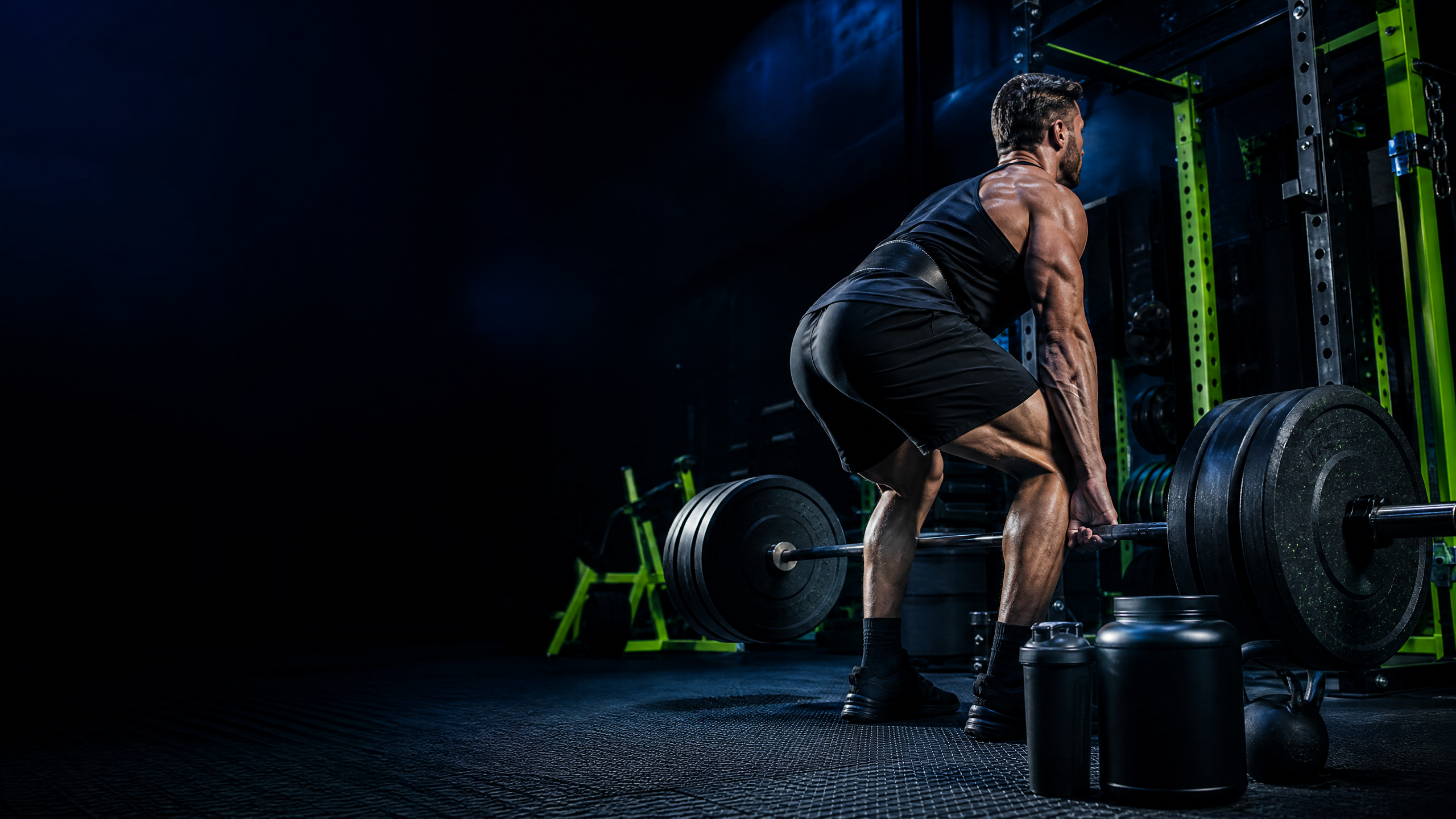 Strength athlete deadlifting beside unbranded supplements in a cobalt performance gym